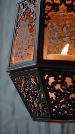 Close-up of an ornate lantern with a lit candle inside, showcasing intricate patterns