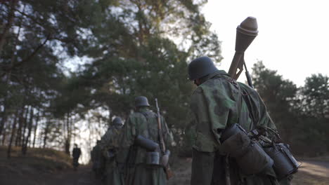 german soldiers marching through forest in wwii