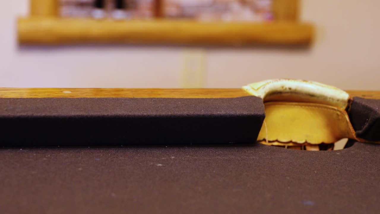 coloridas bolas de billar rodando cerca del bolsillo lateral en la mesa de billar