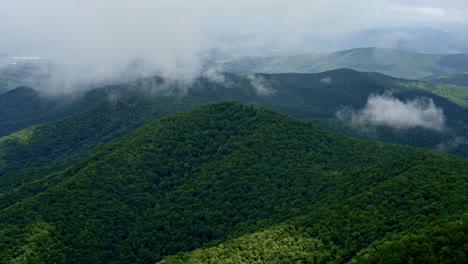 drone captures rolling clouds and mist over an endless smoky wilderness in rainfall