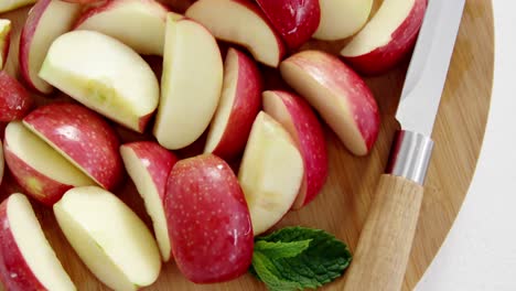 rebanadas de manzanas rojas y cuchillo en la tabla de cortar