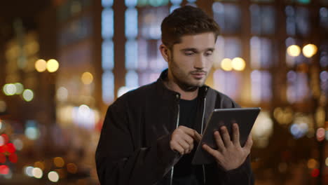 calm man surfing internet on tablet. relaxed guy touching tablet screen outside