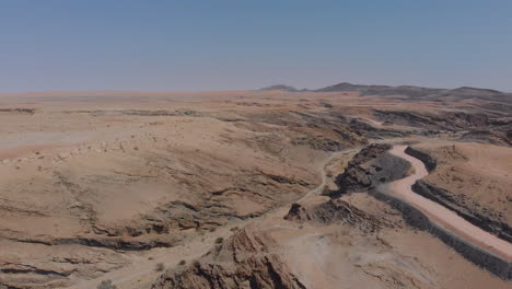 Aerial-rotating-along-road-beside-huge-African-creek