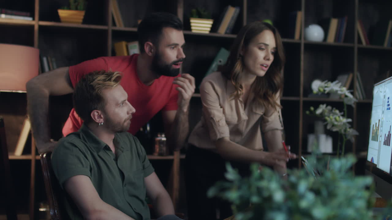 비즈니스 애널리스트 팀이 사무실에서 컴퓨터에서 다이어그램을 보고 있습니다.