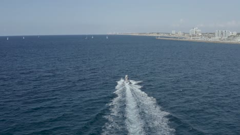 aerial tracking shot motorboat sailing in israel tel aviv sea, drone shot