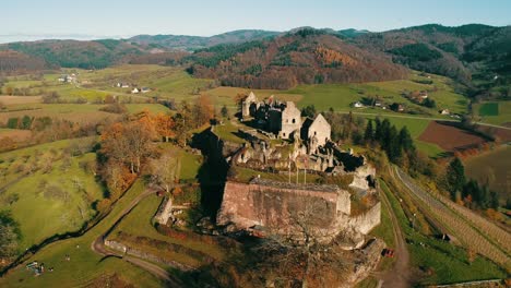 old historic castle ruins on a hill in the middle of an autumnal landscape