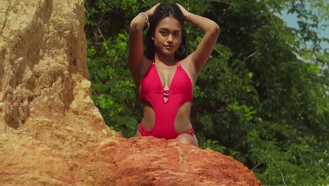 abrazando el calor, una chica de ascendencia india se pasea por una playa tropical del caribe en un bikini rojo