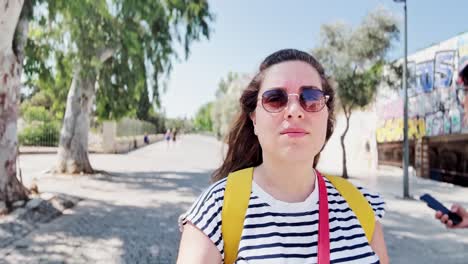 happy young woman walking down an urban street on vacation, athens, greece