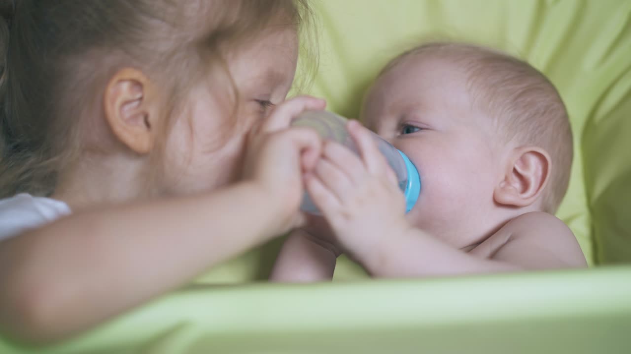 여동생 은 부드러운 고급 의자 에 앉은 소년 에게 물 을 마시게 한다