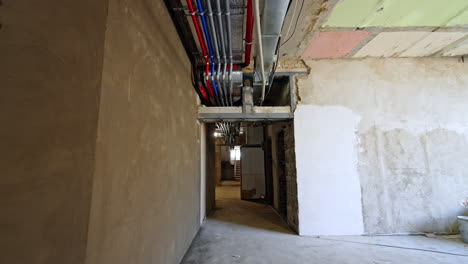walking by the long corridor of the renovated building. a set of wires and pipes on the ceiling. reconstruction concept.