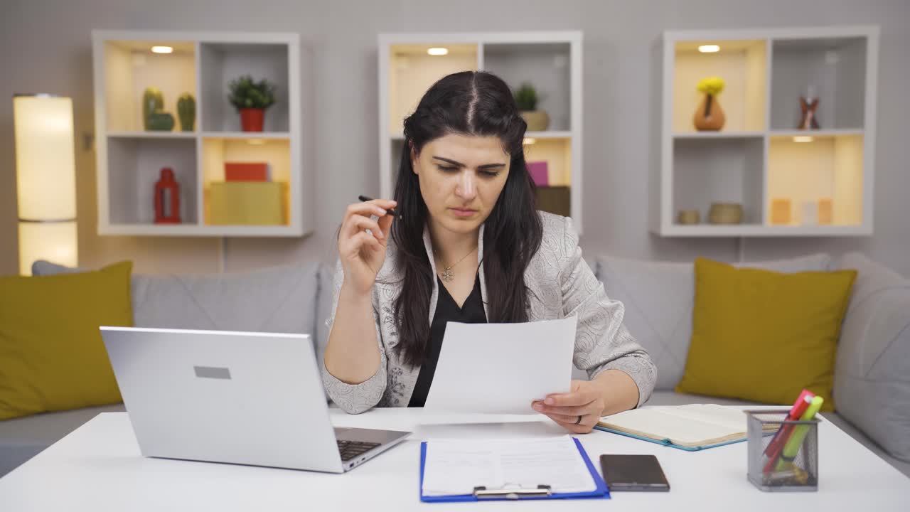 trabajadora de oficina en el hogar examinando, analizando documentos.