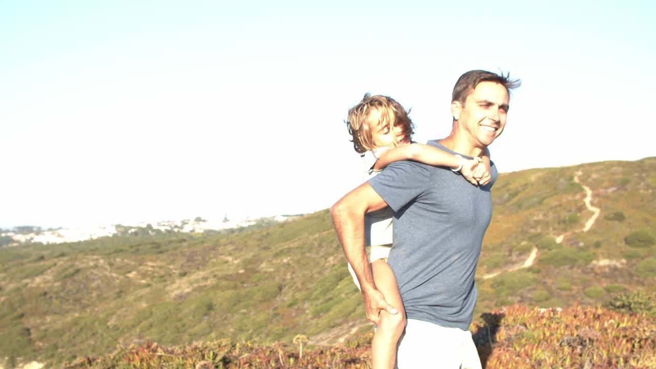 Papá feliz llevando a su hija a cuestas