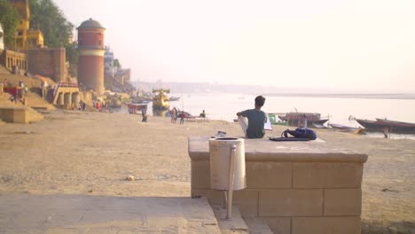 man drawing on the ganges riverbank