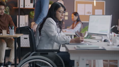 woman in wheelchair working in modern office