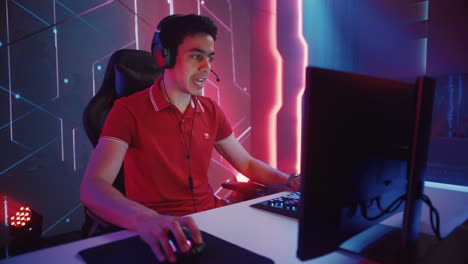 professional esports gamer playing in computer video games, happily and cheerfully celebrates victory and success. online cyber championship / tournament. portrait side view, static camera shot
