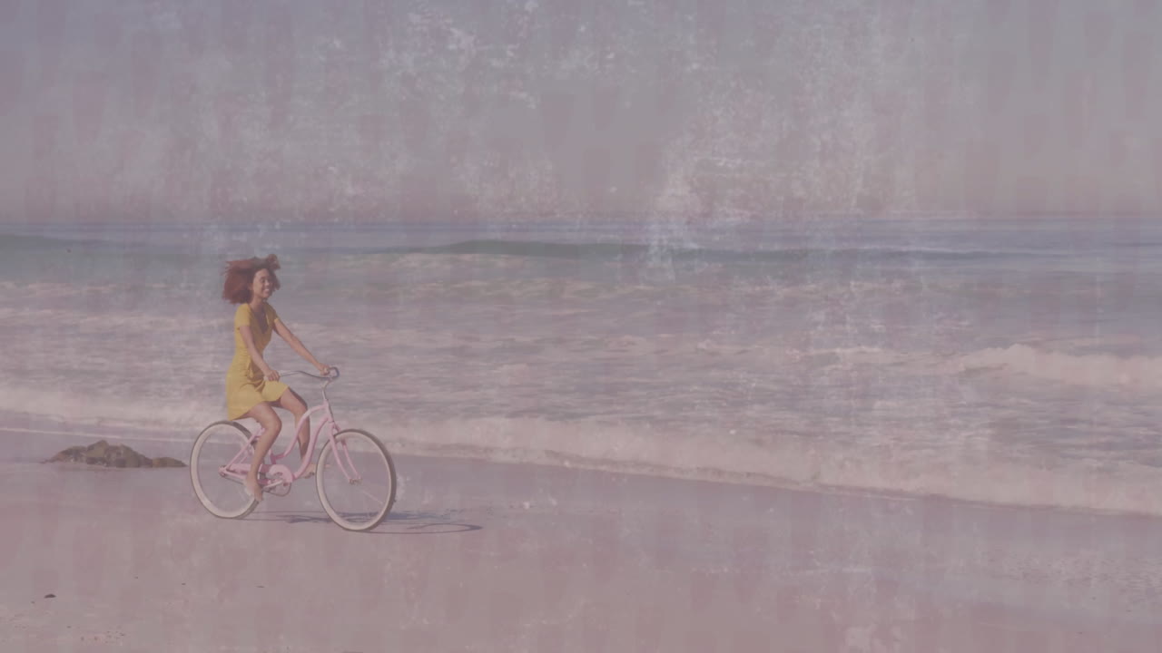 woman pedaling pink cruiser bicycle along beach shoreline, displaying floating health heart icon