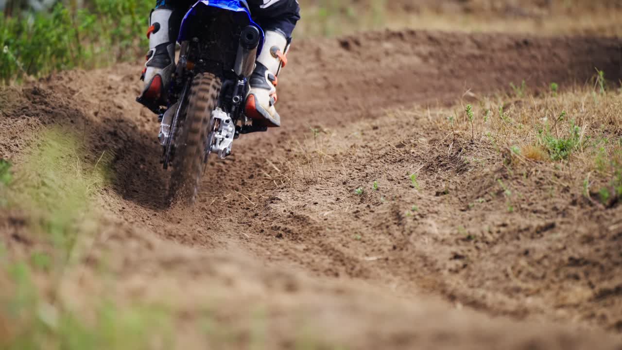 Pilotos de motocross fazendo a curva em uma estrada de terra e areia em câmera lenta