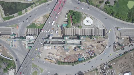aerial top view of public transport electricity train construction in the centre of roundabout and tunnel with cars moving in bangkok thailand