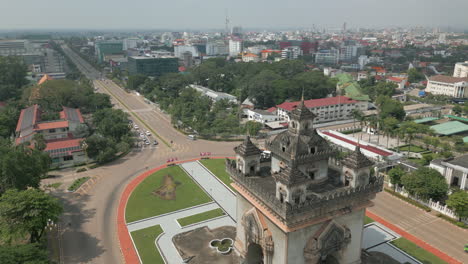 Drone-Tracks-Back-Over-Patuxai-Monument-In-The-Midday-Sun-In-Laos