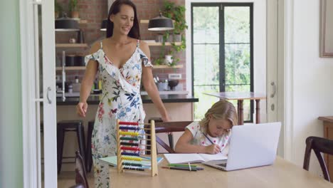 Mother-helping-her-daughter-with-homework-in-a-comfortable-home-4k