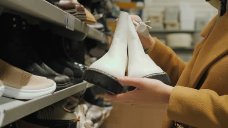 A-middle-aged-woman-chooses-warm-shoes-in-the-store