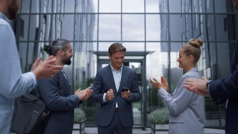 businessman announce happy news to employees. smiling staff applauding leader.