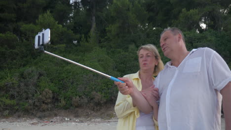 Pareja-Con-Teléfono-Inteligente-Y-Palo-Selfie