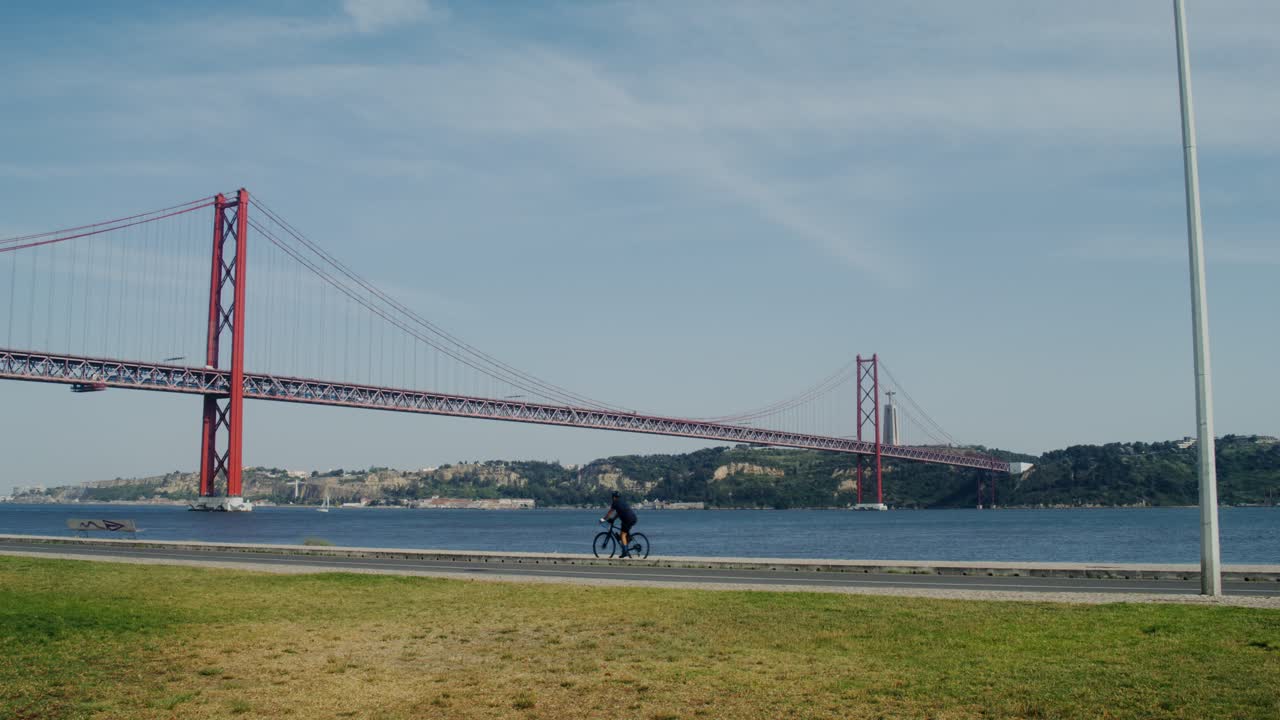 리스본의 25 de abril 다리와 자전거 타는 사람