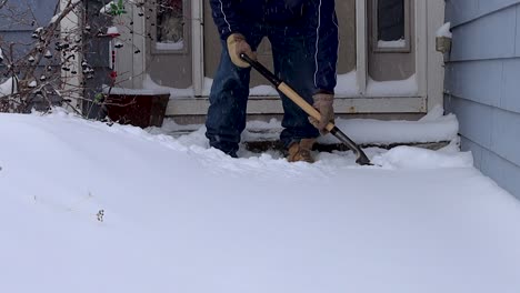 scooping snow to clear the front stoop after a winter storm