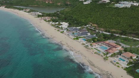 aerial view of vacant baie rouge beach with clean turquoise water and green hills at background in st