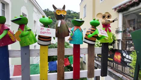 garden frog figurines on wooden fence with german sign "in the garden