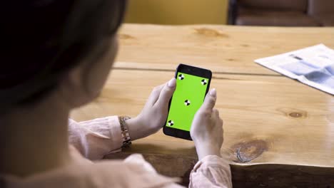 woman using smartphone with green screen