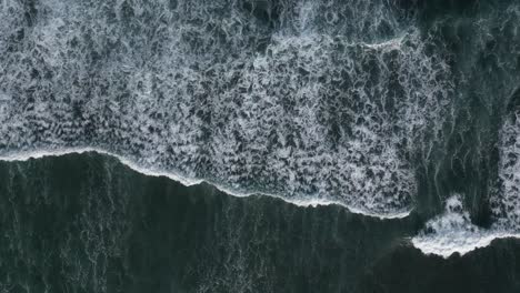 birds eye view of blue, tropical waves on the coast of bali, indonesia