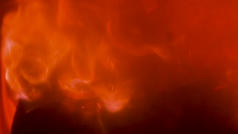 Fire-inferno-close-up,-slow-motion,-flames-engulfing-wooden-log-in-a-stove,-abstract-red-and-orange-background