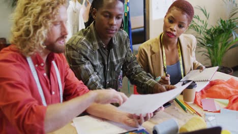 happy diverse business people discussing work with documents at office