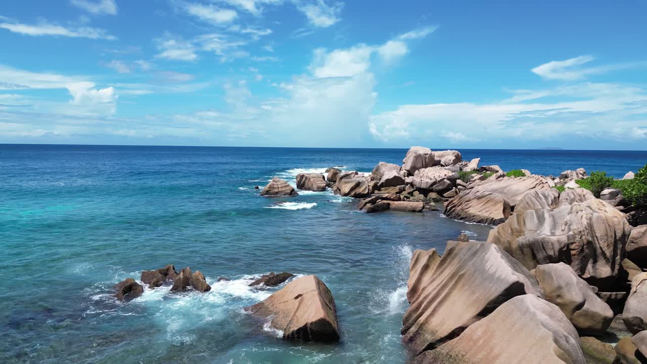 drone fly close to secluded paradise beach with rocks and tropical palm tree vegetation in La Digue Island, Seychelles archipelago Indian Ocean