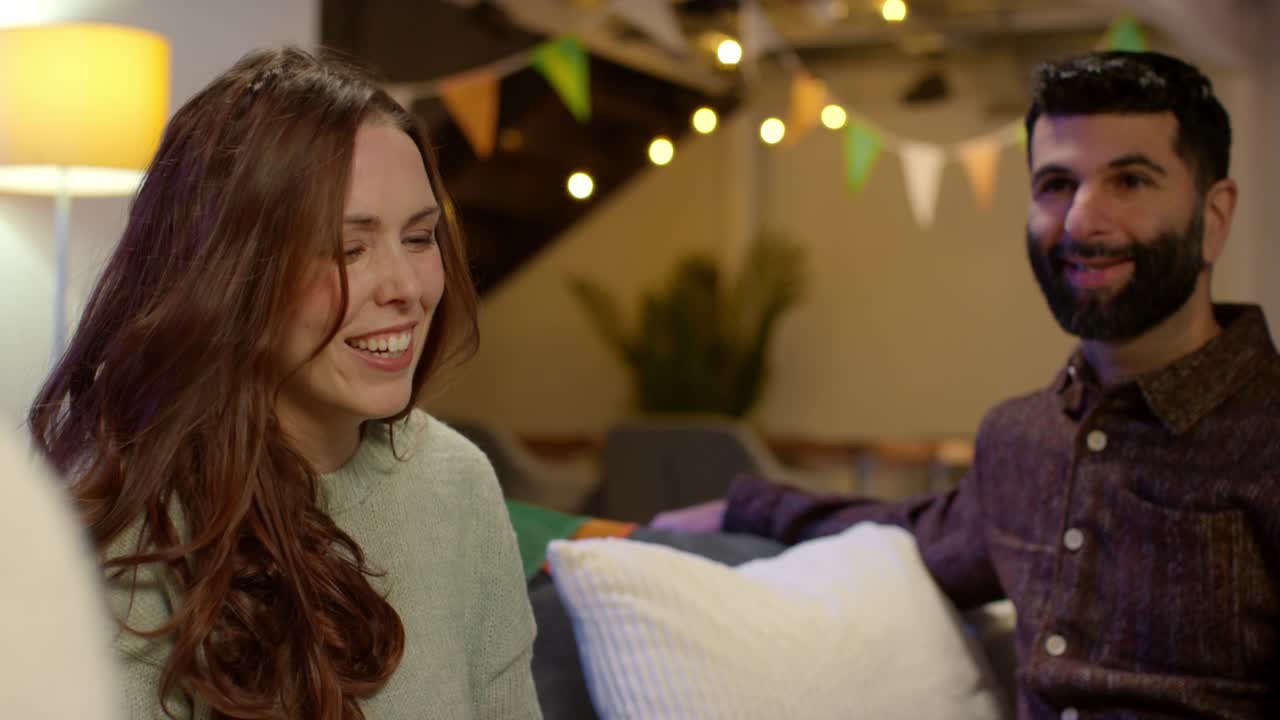 집에서 친구 그룹은 성 패트릭의 날 파티에서 축하하는 옷을 입고 알코올을 마시고 환호합니다.