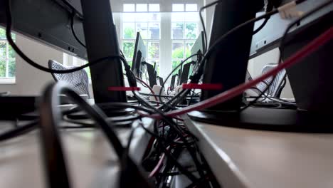 modern office filled with computer monitors and tangled cables, reflecting the busy and tech-driven work environment