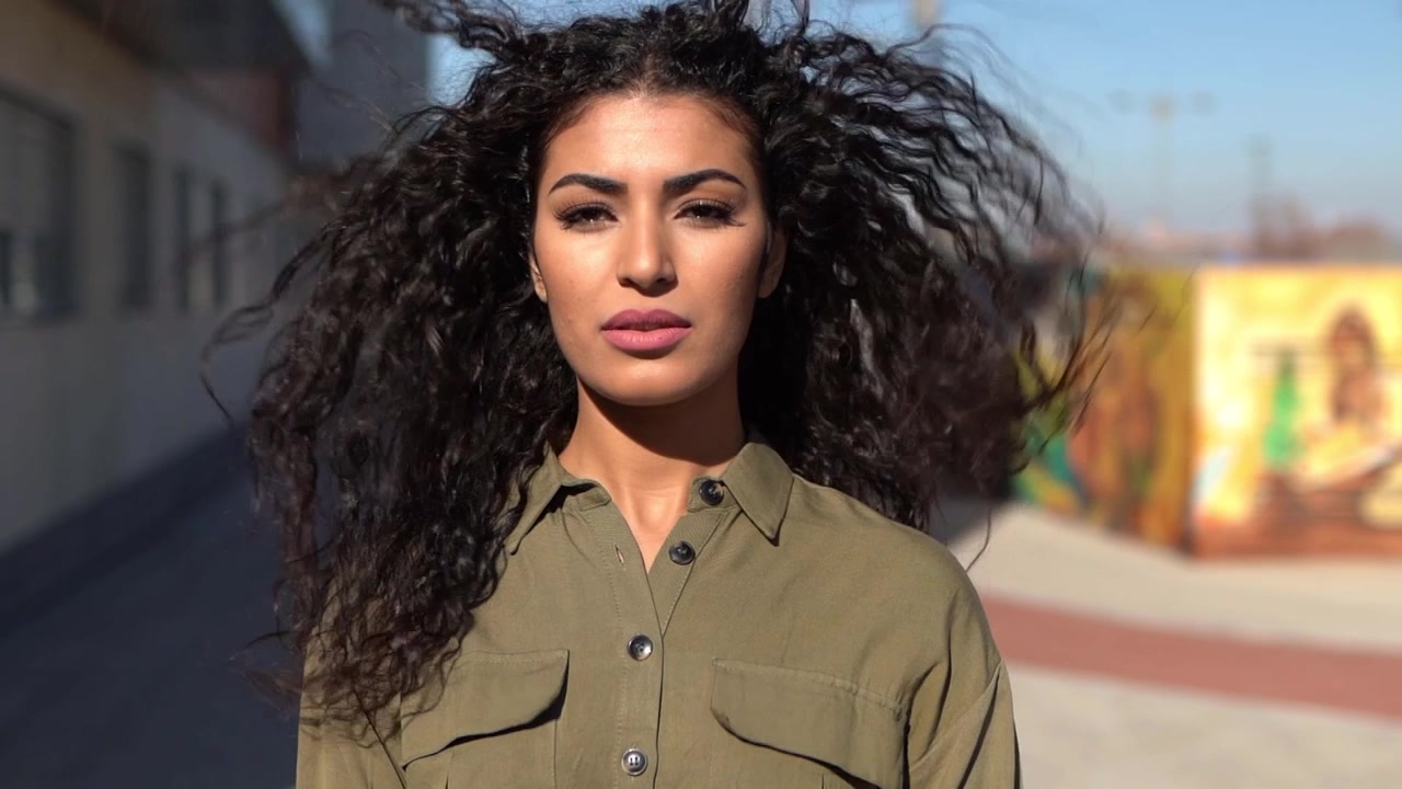 Giovane donna araba che muove i suoi capelli neri ricci