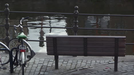 stopping place at a waterfront, with a wooden bench and bicycle stand