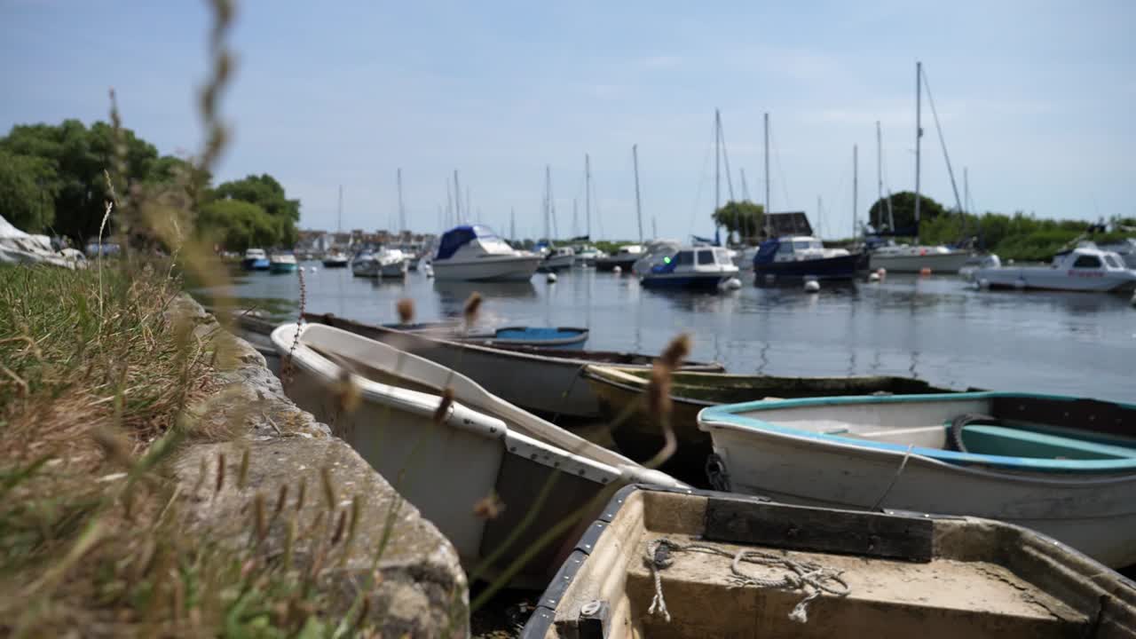 A group of old and new fishing boats sitting in a harbour on a sunny day