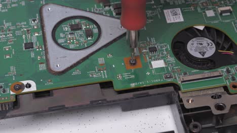 laptop component motherboard tightening the screw assembling parts hand