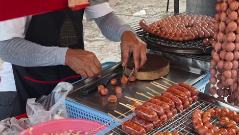 vendedor callejero preparando salchichas a la parrilla