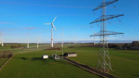 clean energy generation: drone shot of rotating windmills and power line in brilon, north rhine-westphalia