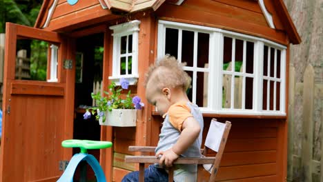 Baby-boy-sitting-on-chair-near-play-house-4k