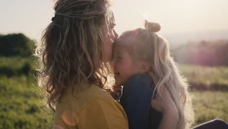 Mom-with-little-daughter-sitting-on-the-meadow-and-bonding-together.