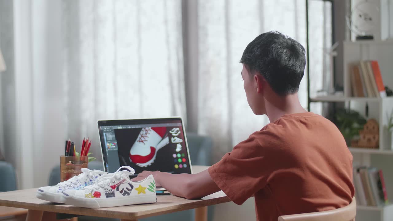 Young person designing shoes on a laptop