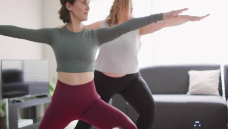 Caucasian-lesbian-couple-keeping-fit-and-practicing-yoga-on-mat