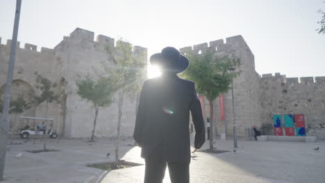 orthodox jewish man stands facing jaffa gate, jerusalem