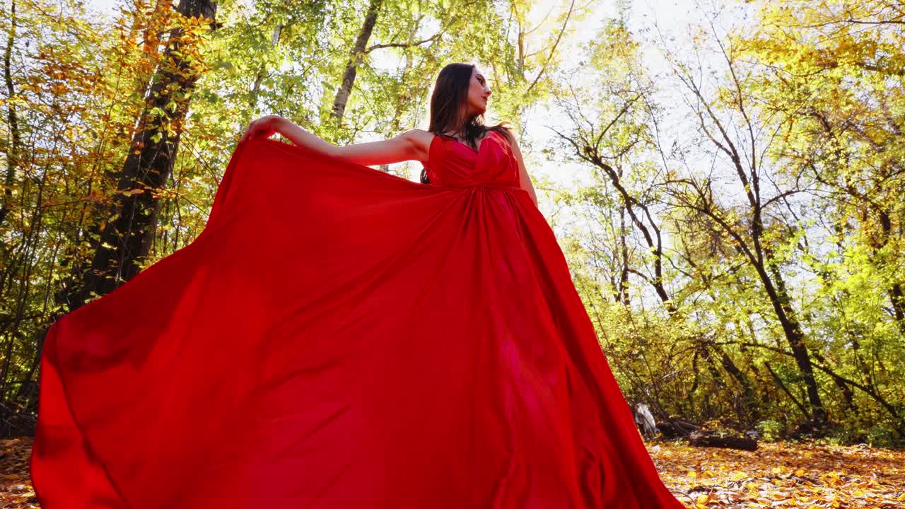 A Captivating Dance in Nature: A Graceful Model Twirling in a Flowing Dress Amidst Vibrant Autumn Colors and Sunlit Forest Surroundings